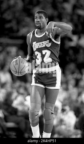 NBA-Superstar Ervin 'Magic' Johnson von den Los Angeles Lakers bringt den Ball während eines Spiels gegen die Chicago Bulls in den 1980s. Stockfoto