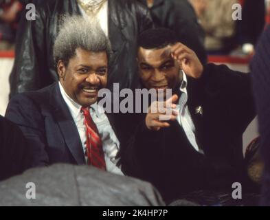 Der Boxpromoter Don King und der Schwergewichtsboxmeister Mike Tyson gaben den Fotografen bei einem Basketballspiel der Chicago Bulls, CA. 1990 Stockfoto