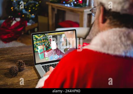 weihnachtsmann macht Laptop weihnachten Videoanruf mit Person hält Smartphone. weihnachten, Festlichkeit und Kommunikationstechnik. Stockfoto