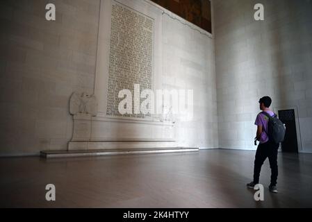 Ein junger Mann liest Abraham Lincolns Gettysburg-Adresse, die an der Wand des Lincoln Memorial in Washington, DC, verewigt ist. Stockfoto