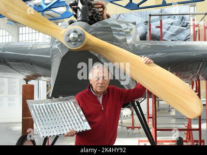 29. September 2022, Sachsen-Anhalt, Dessau-Roßlau: Im Technikmuseum „Hugo Junkers“ steht Ehrengeschäftsführer und ehemaliger Handelspilot Gerd Fucke vom Förderverein Technikmuseum Hugo Junkers e.V. mit Blechkastenfolie an der Nachbildung des ersten Vollmetallflugzeugs der Welt, einer J1 aus dem Jahr 1915. Das Flugzeug, das nicht in Serie ging, wurde nur von den Mitgliedern des Fördervereins mit Blechdosen-Folien nach Übersichtszeichnungen und Detailfotos nachgebildet. Es ist eine der besonderen Exhibit Stockfoto