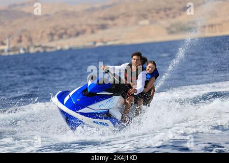 Eilat, Israel - am 27. September 2022 fährt die Familie mit einem Wasserscooter auf dem Roten Meer. Wassersport, Jet-Ski fahren Stockfoto