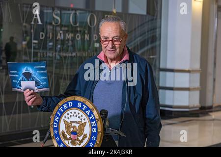 NEW YORK, NY – 02. OKTOBER: Der Mehrheitsführer des Senats, US-Senator Chuck Schumer (D-NY), hält am 2. Oktober 2022 in New York City ein Schild mit einem symbolischen Hacker auf. Der New Yorker Senator Chuck Schumer fordert die Bundesregierung auf, mehr Informationen über die jüngsten Datenschutzverletzungen zu veröffentlichen und ihre Anstrengungen zum Schutz der Verbraucher vor Cyber-Sicherheitsverletzungen zu verstärken und die Verantwortlichen für solche Hacks zu untersuchen. Kredit: Ron Adar/Alamy Live Nachrichten Stockfoto