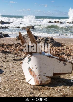 Gebrochenes Vorderteil des Bootes, das an Land gespült wurde Stockfoto