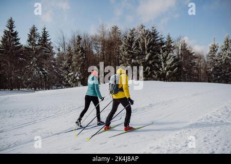 Seniorenpaar Skifahren gemeinsam mitten im Wald Stockfoto