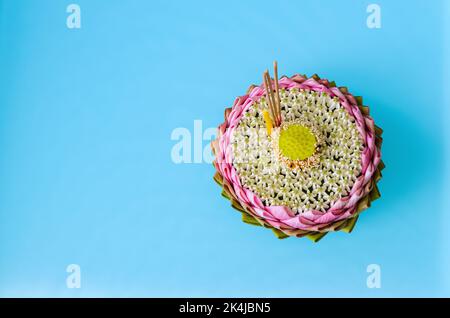 Das rosa Lotusblütenblatt krathong schmückt mit seinem Pollen, der Kronenblume, dem verschwommenen Räucherstäbchen und der Kerze für das Thailand Loy Krathong Festival auf Licht Stockfoto