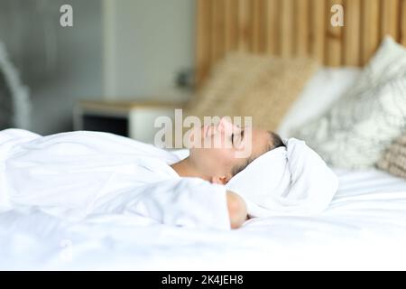 Glückliche Frau, die sich nach dem Duschen zu Hause auf dem Bett ausruhte Stockfoto