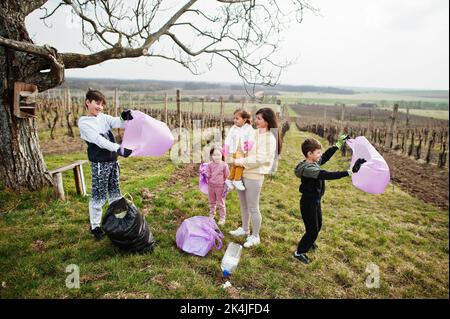 Familie mit Müllsack sammeln Müll während der Reinigung in den Weinbergen. Umweltschutz und Ökologie, Recycling. Stockfoto