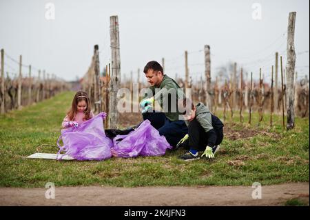 Familie mit Müllsack sammeln Müll während der Reinigung in den Weinbergen. Umweltschutz und Ökologie, Recycling. Stockfoto