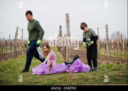Familie mit Müllsack sammeln Müll während der Reinigung in den Weinbergen. Umweltschutz und Ökologie, Recycling. Stockfoto
