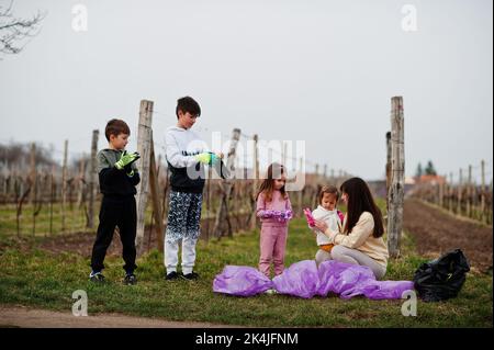 Familie mit Müllsack sammeln Müll während der Reinigung in den Weinbergen. Umweltschutz und Ökologie, Recycling. Stockfoto