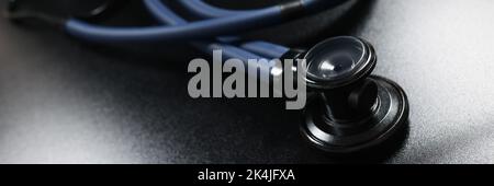 Arzt Stethoskop-Geräte auf dunkler Oberfläche, Werkzeug für die Patientendiagnostik Stockfoto