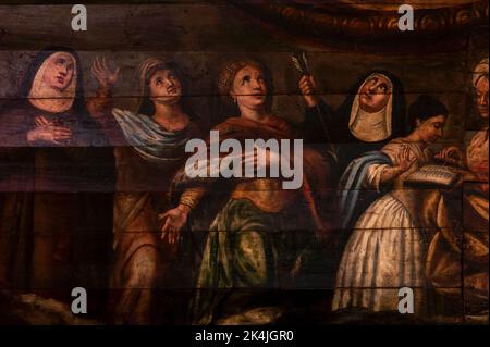 Heiligenfrauen blicken in den Himmel: Details des südlichen Frieses, gemalt im rustikalen Barockstil von lokalen oder regionalen Künstlern der frühen 1700er Jahre unter dem hölzernen schiffsförmigen Gewölbe über dem Schiff der mittelalterlichen Eglise Saint-Martin (Kirche St. Martin) in Lévignacq in den Landes, Nouvelle-Aquitaine, Frankreich. Stockfoto