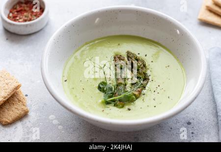 Entgiften Sie grüne Suppe mit Spargel in einer weißen Schüssel Stockfoto