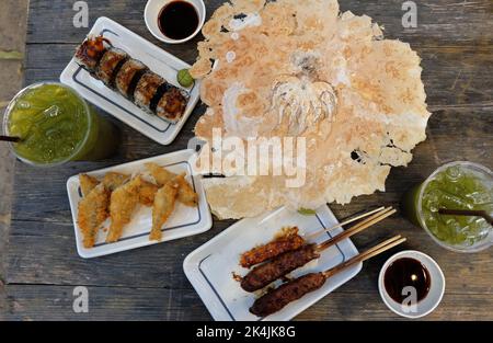 Izakaya (japanisches Street Food) Chicken Teriyaki-Spieße, frittierter Fliegende Fische, Sushi Maki-Brötchen, Kaisen Don (Sashimi-Reisschüssel), Senbei Stockfoto