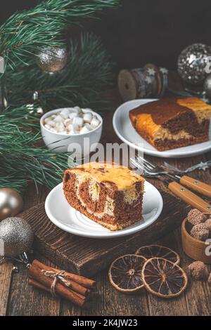 Kuchen auf einem weihnachtlichen Hintergrund mit Weihnachtsschmuck. Frohe Weihnachten und Frohes neues Jahr. Stockfoto