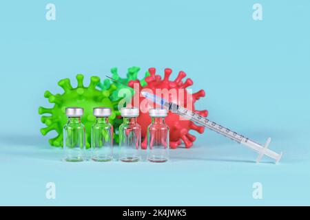 Corona Booster-Impfstoff-Konzept mit 4 Vials mit Spritze und Virusmodellen im Hintergrund Stockfoto