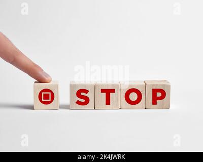 Finger drückt die Pause-Taste auf Holzwürfel. Stockfoto
