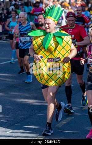 Simon Howard läuft beim TCS London Marathon 2022 auf der Tower Hill Road, City of London, Großbritannien, und trägt ein Ananas-Kostüm Stockfoto