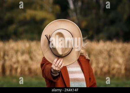 Cowboyhut in weiblicher Hand. Bäuerin in ländlicher Umgebung Stockfoto
