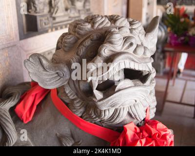 Eine steinerne Löwenstatue vor dem Hauptschrein des Dajia Jenn Lann Tempels in Taichung, Taiwan. Stockfoto