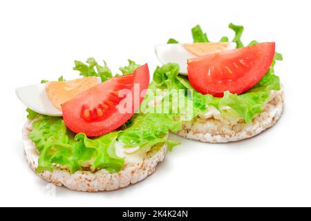 Reiskuchen-Sandwiches mit Tomaten, Salat und Ei - isoliert auf Weiß. Einfaches Frühstück. Diät-Essen. Schnelle und gesunde Sandwiches. Knäckebrot mit leckerer Füllung. Gesunde Ernährung Snack - Isolation Stockfoto