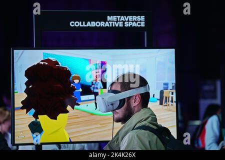 Virtual-Reality-Ausstellung. Der junge Mann trägt eine Virtual-Reality-Brille und erlebt eine metaverse Begegnung. Turin, Italien - September 2022 Stockfoto