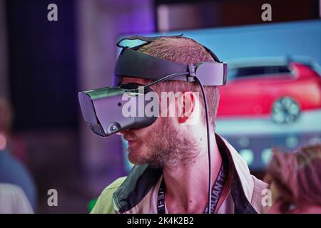 Virtual-Reality-Ausstellung. Der junge Mann trägt eine Virtual-Reality-Brille und erlebt eine metaverse Begegnung. Turin, Italien - September 2022 Stockfoto