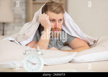 Junger gutaussehender Mann, der Probleme beim Schlafen hat Stockfoto