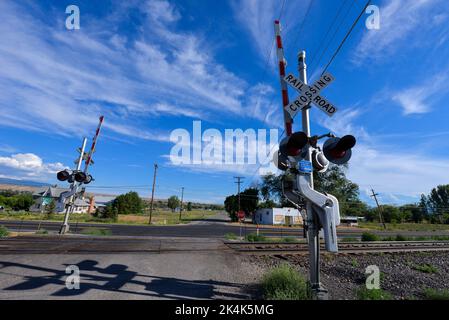 Die Verkehrssignale sind offen, so dass Autos eine Eisenbahnlinie in der Nähe von Fruita in Colorado, USA, überqueren können Stockfoto