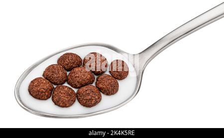 Schokoladen-Maiskugeln mit Milch im Löffel isoliert auf weißem Hintergrund Stockfoto