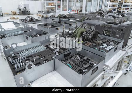 Nahaufnahme von Objekten, Werkzeugen und Ersatzteilen auf der Montagelinie von Übertragungseinrichtungen in der Industriefabrik. Stockfoto