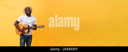 In voller Länge Foto von Angeregten künstlerische Mann, der seine Gitarre spielen. Auf gelben Hintergrund. Stockfoto