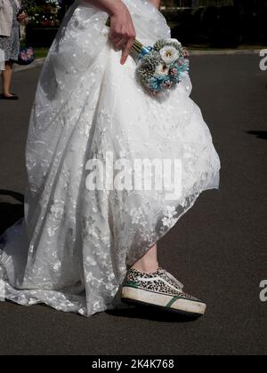 Braut trägt Sportschuhe, Großbritannien Stockfoto