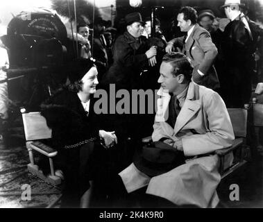 LESLIE HOWARD mit Besuch der Picture Show die britische Filmzeitschrift Journalist KATHLYN HAYDEN mit Regisseur FRANK BORZAGE im Hintergrund (mit Pfeife) am Drehort in Palm Springs während der Dreharbeiten zu SECRETS 1933 Regisseur FRANK BORZAGE Mary Pickford Company / United Artists Stockfoto