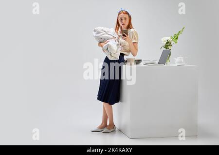 Berufstätigen Müttern. Business und Housekeeping. Beschäftigte Mutter mit Baby, Multitasking Frau. Karriere, Mutterschaft, Geschäft und Emotionen Stockfoto