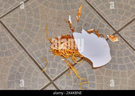 Abgefallener Teller mit Pasta auf dem Küchenboden Stockfoto