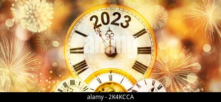2023 Neujahr mit Feuerwerk und Uhr, die bis Mitternacht mit defokusserem goldenen Hintergrund zählt Stockfoto