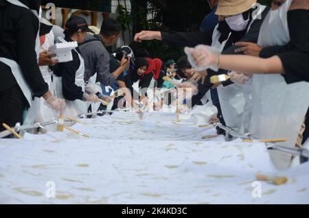 Malang, Ost-Java, Indonesien. 2. Oktober 2022. 500 Menschen mit Behinderungen versammelten sich auf dem Stadtplatz von Malang, um Batik zum Gedenken an den nationalen Batik-Tag zu machen, der fällt. Die UNESCO erkennt die Batik als Welterbe an, weil sie die Kriterien erfüllt, einschließlich der Fülle an Symbolen und philosophischen Bedeutungen des Lebens des indonesischen Volkes. Batik ist eine Ikone der indonesischen Nation, auf die man stolz sein und sie bewahren muss. (Bild: © Moch Farabi Wardana/Pacific Press via ZUMA Press Wire) Stockfoto