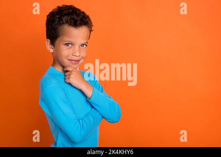 Foto von ziemlich nett Junge betrachten treffen Entscheidung Wahl wählen tragen stilvolle Pullover leeren Raum isoliert auf orangefarbenem Hintergrund Stockfoto