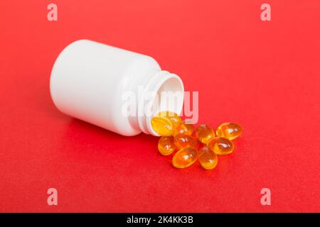 Omega-3 Kapseln liegen in einer weißen Flasche auf einem Tischhintergrund. Fischöl Tabletten Draufsicht. Biologisch aktive Zusatzstoffe. omega 6, Omega 9, Vitamin A, E, Stockfoto