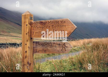 Holzschild für Pfad zum Wainwright Fleetwith Pike & Honister Hause in der Nähe von Buttermere im Lake District National Park, Cumbria, England, Großbritannien. Stockfoto