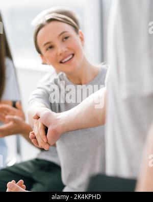 Junge Mitarbeiter grüßen sich mit Handschlag Stockfoto