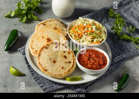 Hausgemachte salvadorianische Maispuppen mit Curtido und Salsa Stockfoto