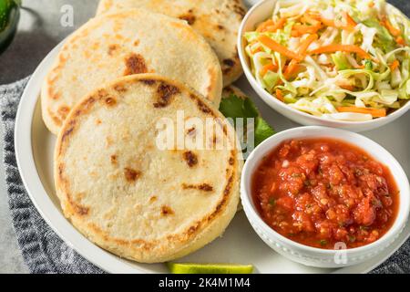 Hausgemachte salvadorianische Maispuppen mit Curtido und Salsa Stockfoto
