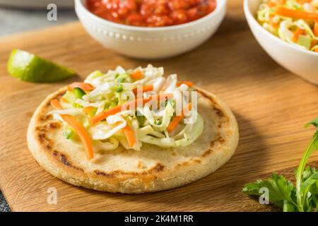 Hausgemachte salvadorianische Maispuppen mit Curtido und Salsa Stockfoto