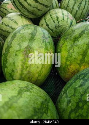 Nahaufnahme von frischen Wassermelonenfrüchten am Stand des Supermarkts in Asien. Gesundes und leckeres Dessert. Selektiver Fokus. Stockfoto