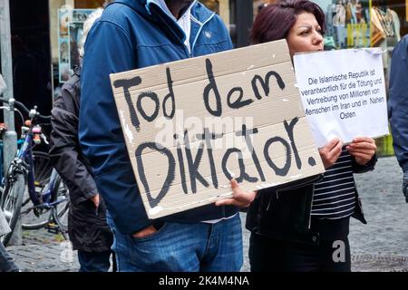 Braunschweig, 1. Oktober 2022: Demonstranten gegen die iranische Regierung halten ein Plakat hoch, auf dem sie den Tod des Diktators wünschen Stockfoto