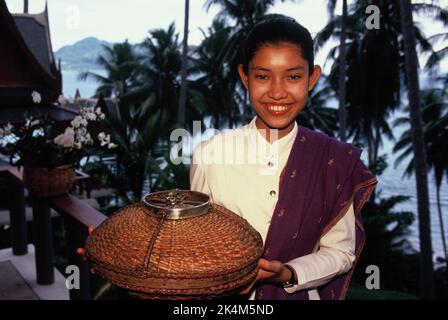 Thailand. Phuket. Amanpuri. Junge Thailänderin, Hotelkellnerin in traditioneller Kleidung. Stockfoto