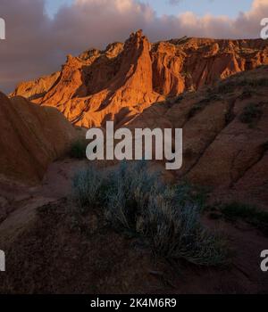 Dramatischer Sonnenuntergang am farbenfrohen Skazka Fairyale Canyon in Issyk-Kul Region, Kirgisistan Stockfoto